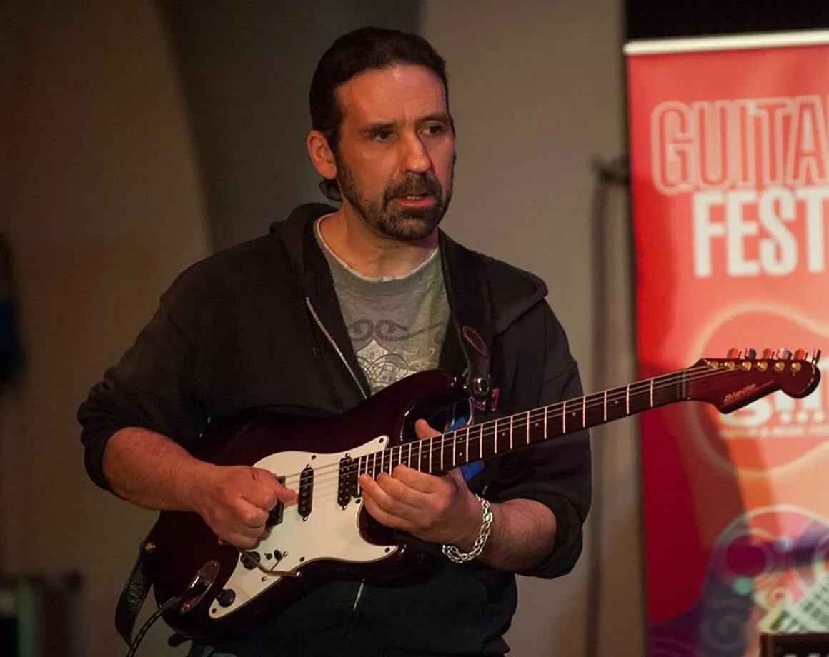 Headshot of professional guitar teacher Pete Sklaroff in his studio.